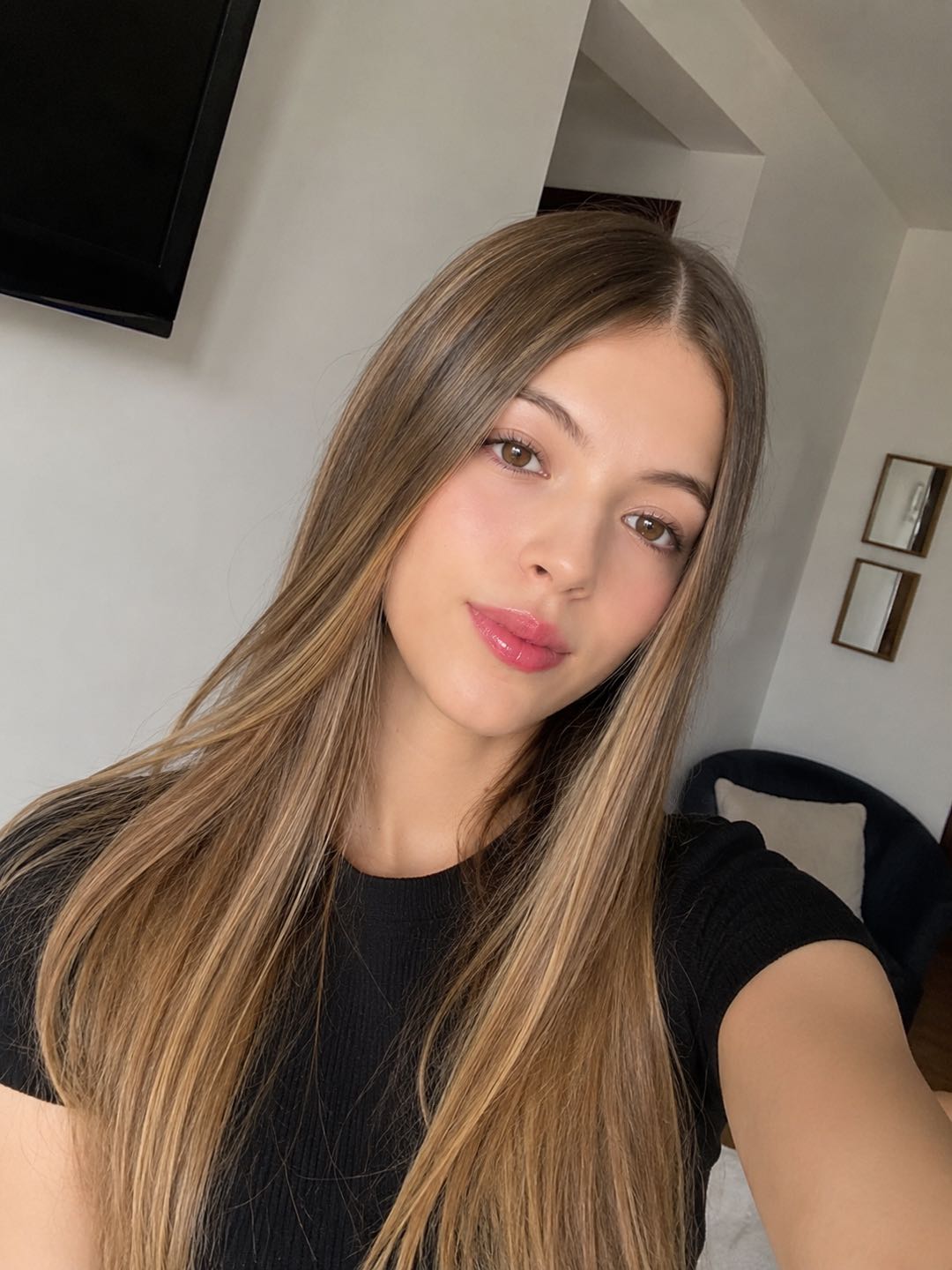 Woman with long hair in a black T-shirt taking a selfie