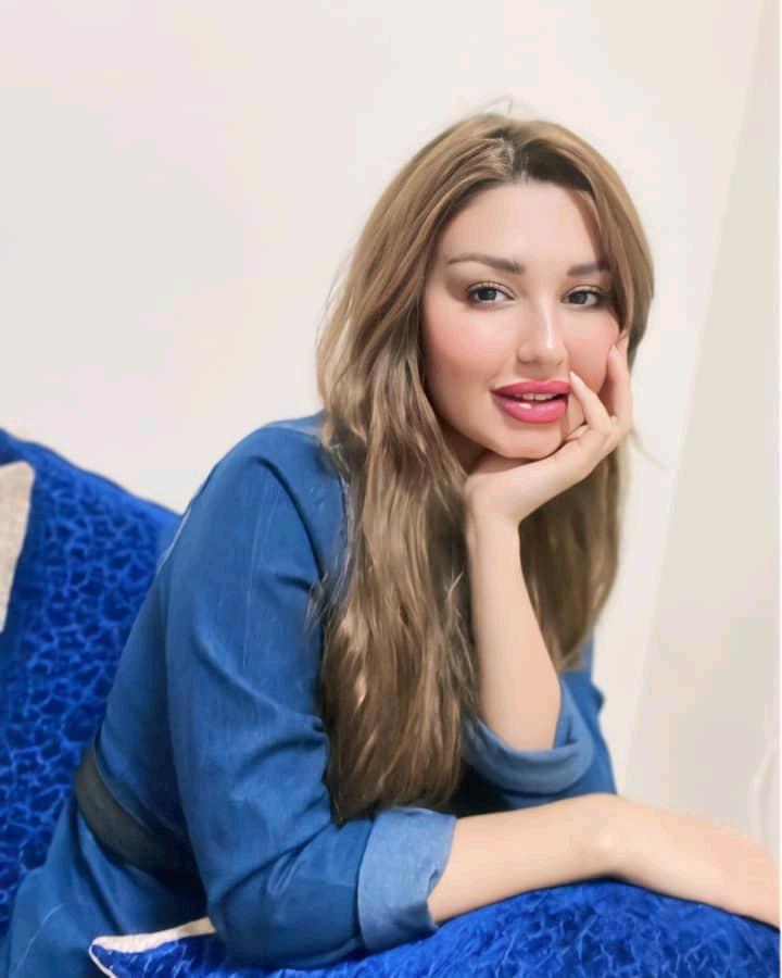Woman in a denim shirt resting her chin on her hand and listening