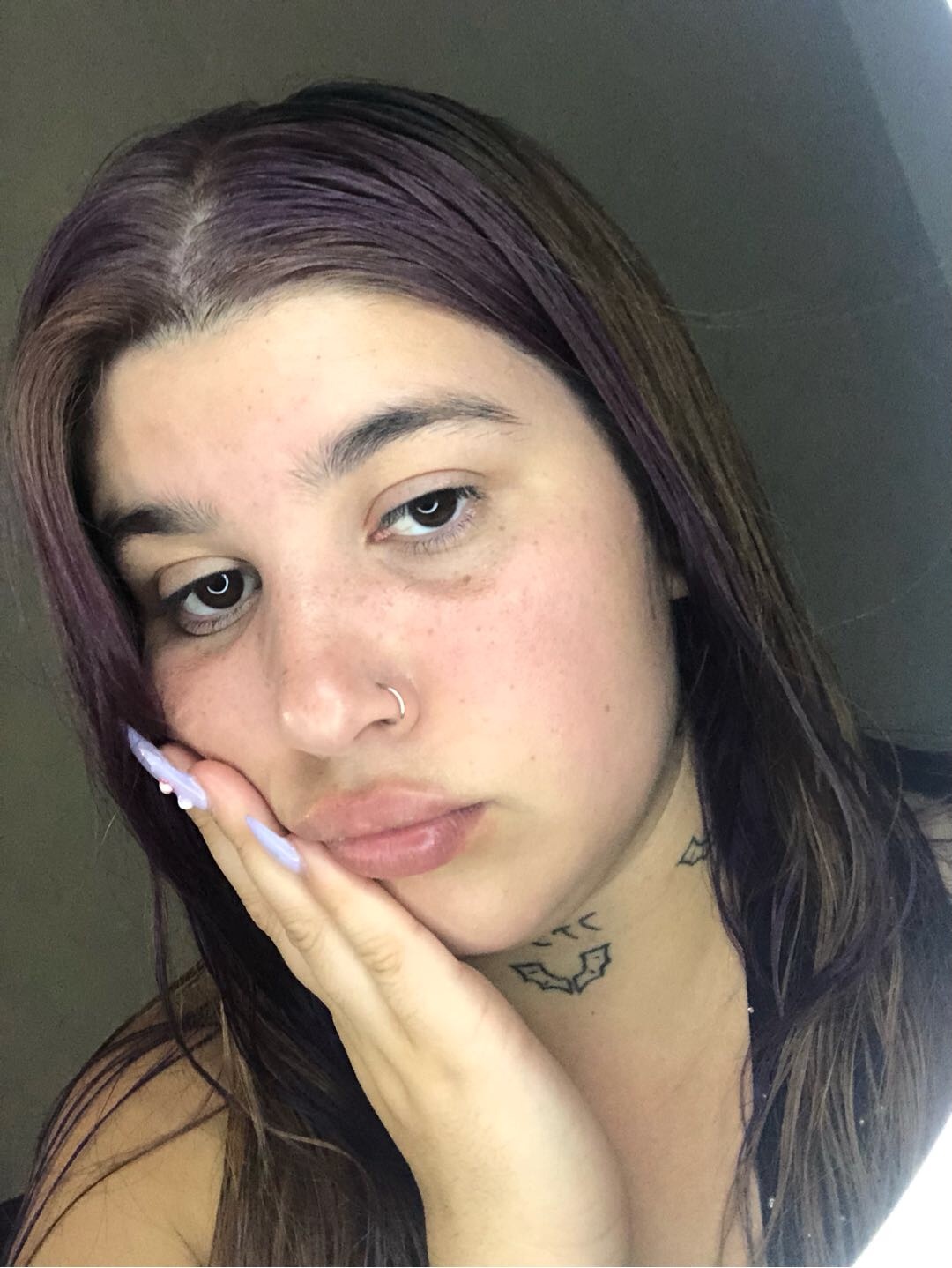 Woman resting her cheek on her hand with a thoughtful expression