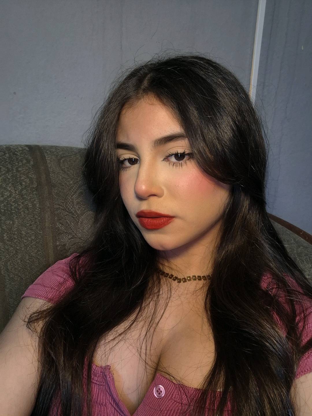 Woman with long dark hair looking into her front camera, filling a video call screen