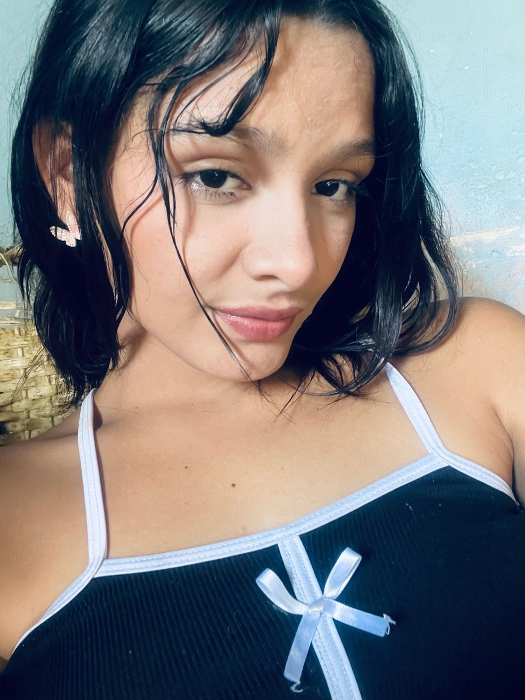 Woman with a short dark bob looking into her front camera