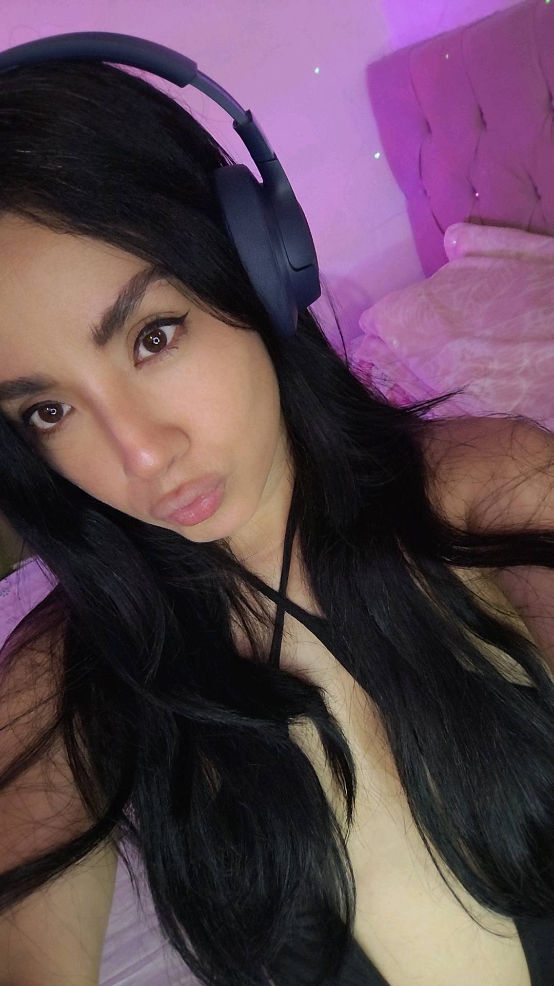 Woman with long dark hair wearing headphones